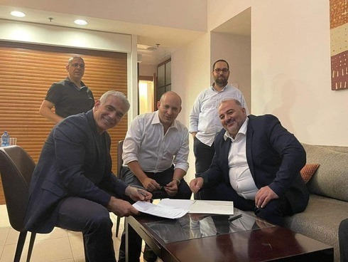 Yair Lapid, de Yesh Atid (izquierda), Naftali Bennett, de Yamina (centro), y Mansour Abbas, de Raam, firman el acuerdo de coalición.