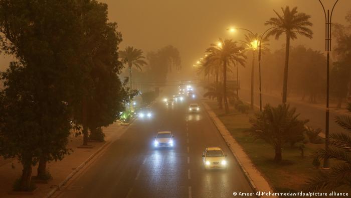 Irak, Bagdad |  Los vehículos cruzan una carretera durante una tormenta de arena