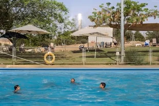 Niños nadando en una piscina pública cerca de la torre solar, en Ashalim, Israel, el 4 de julio de 2022. 