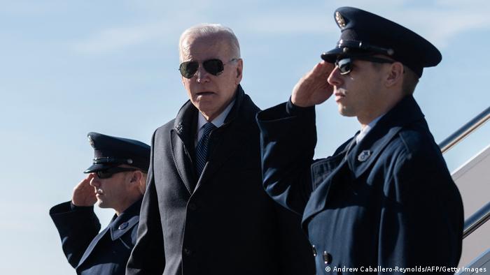 El presidente de los Estados Unidos, Joe Biden, flanqueado por dos militares que saludan